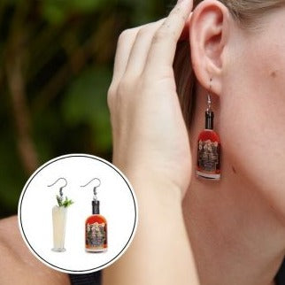 Close-up of woman wearing liquor-inspired acrylic miniature rum bottle earrings with stainless steel hooks.