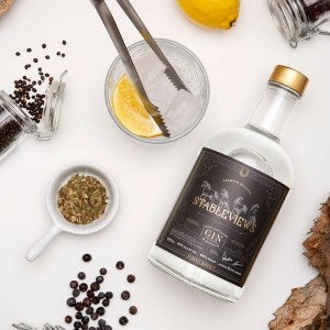The Illegal Tender Rum Co Gin Garnish Pack laid flat on a table surrounded by lemon, peppercorns, and garnish serving as the perfect complement for premium liquor cocktails.